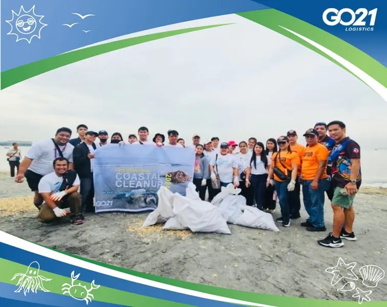 GO21 employees at the shore with sacks of collected trash during the 2024 coastal cleanup drive